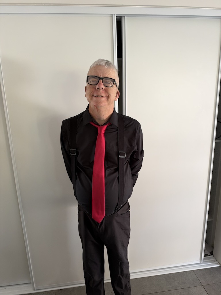 A man dressed in a black shirt and red tie
