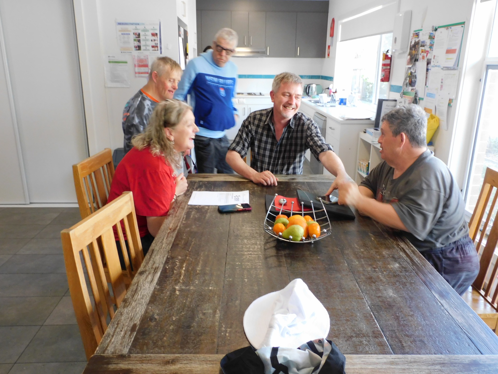 People sharing a conversation around a kitchen table