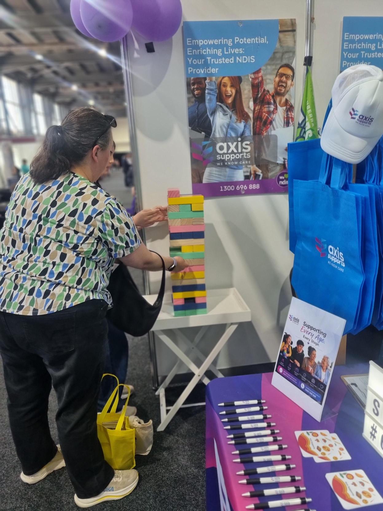 A visitor playing a colourful block game at the AXIS expo stand
