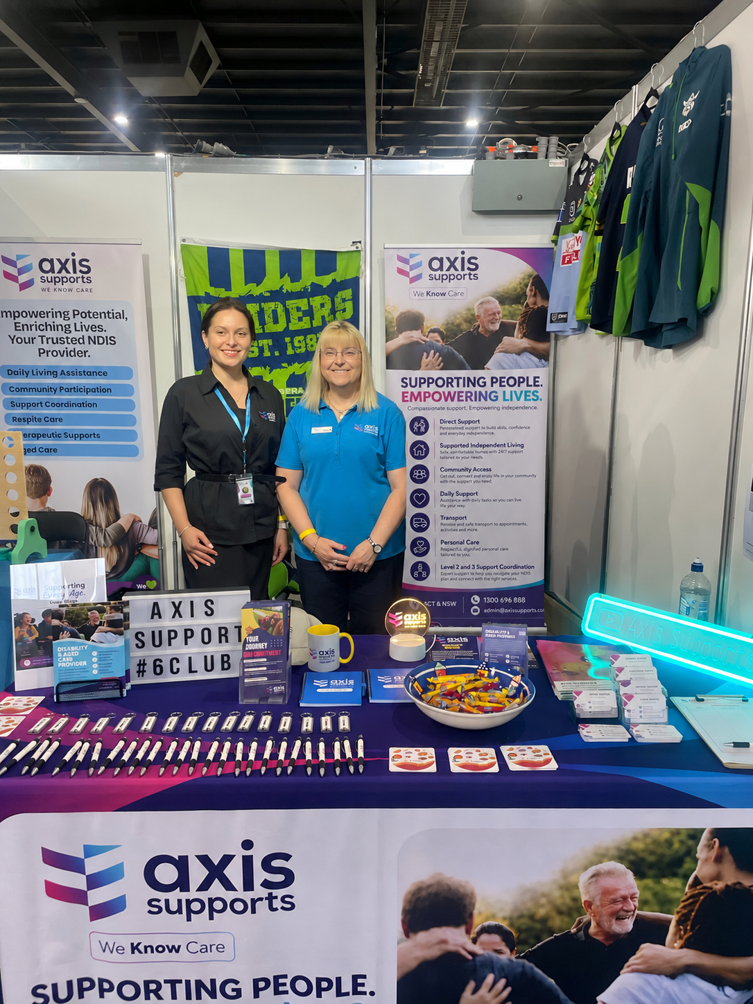 Two AXIS Supports team members smiling at an expo stall